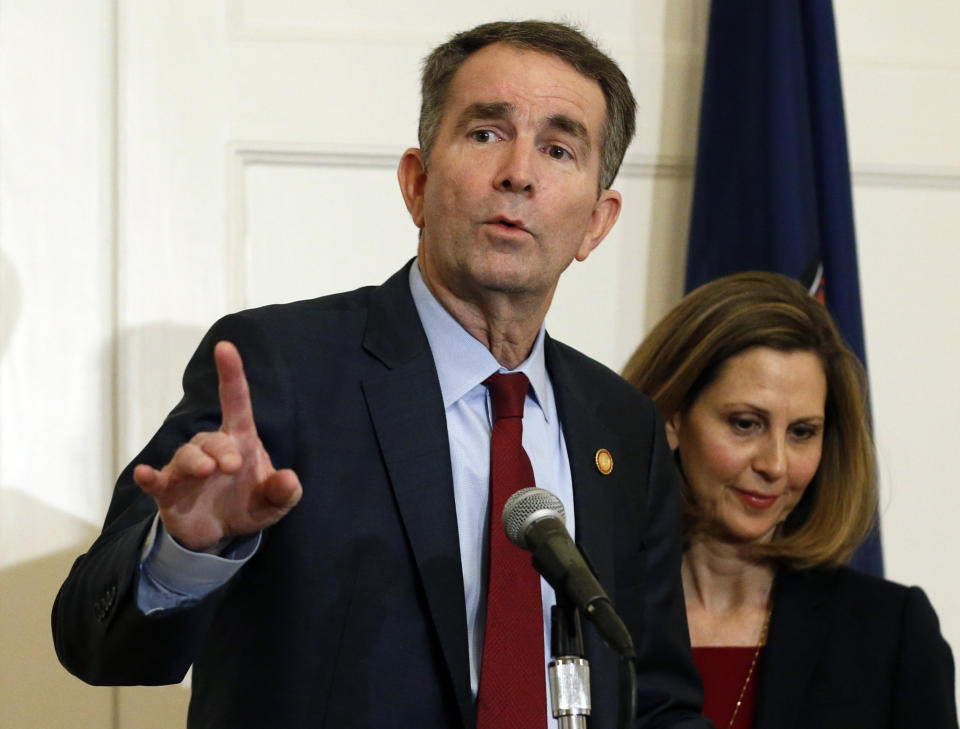 FILE - In this Feb. 2, 2019 file photo Virginia Gov. Ralph Northam, left, gestures as his wife, Pam, listens during a press conference in the Governors Mansion at the Capitol in Richmond, Va. A commission Northam tasked with researching racist laws from the state’s past recommended Thursday, Dec. 5, 2019, that dozens be repealed in order to purge the state’s books of discriminatory language. (AP Photo/Steve Helber, File)