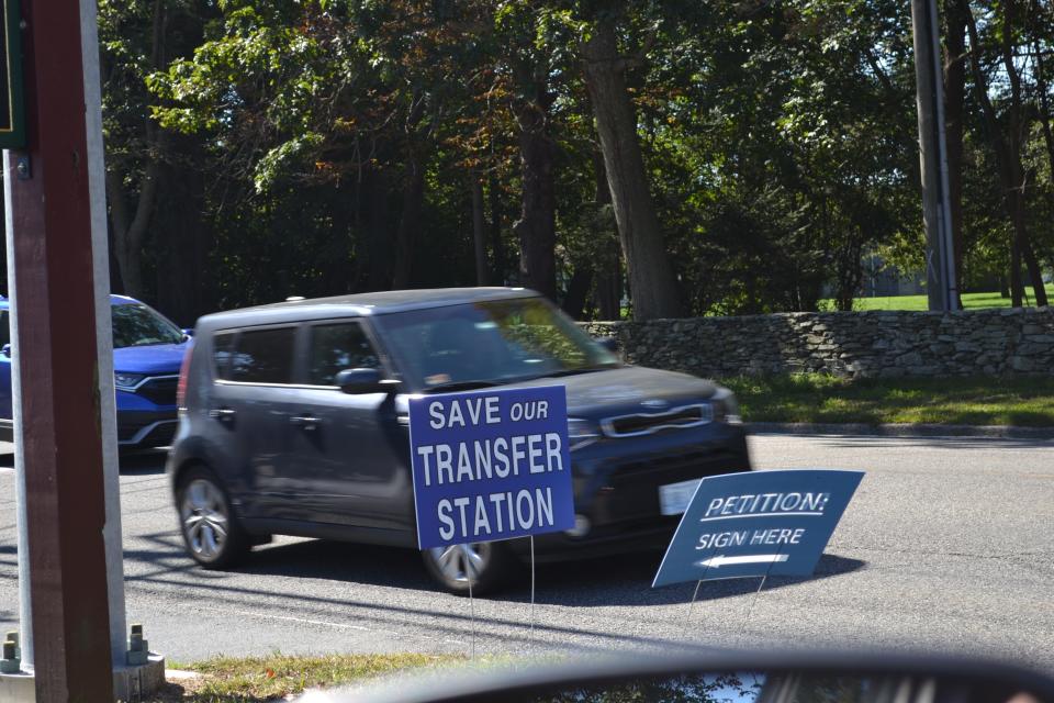 Cars drive by a pair of signs in early October promoting a petition drive at Glen Farm to keep the Portsmouth transfer station open.