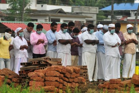 Relatives wearing masks attend the funeral a victim, who lost his battle against the brain-damaging Nipah virus, at a burial ground in Kozhikode, in the southern Indian state of Kerala, India, May 24, 2018. REUTERS/Stringer