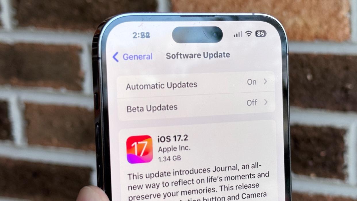  IPhone shown with notification to download iOS 17.2. 