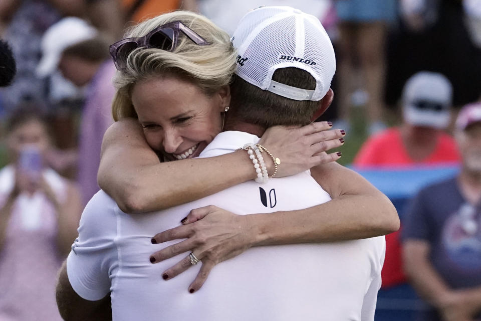 Lucas Glover gets a hug from his wife Krista after winning the St. Jude Championship golf tournament in a playoff Sunday, Aug. 13, 2023, in Memphis, Tenn. (AP Photo/George Walker IV)