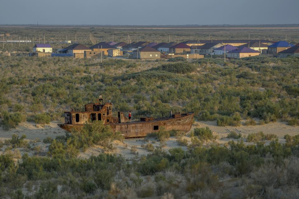 A rusting ship sits in a dried-up area of the Aral Sea in Muynak, Uzbekistan, Sunday, June 25, 2023. The demise of the once-mighty sea has affected thousands of residents and their livelihoods for decades. (AP Photo/Ebrahim Noroozi)