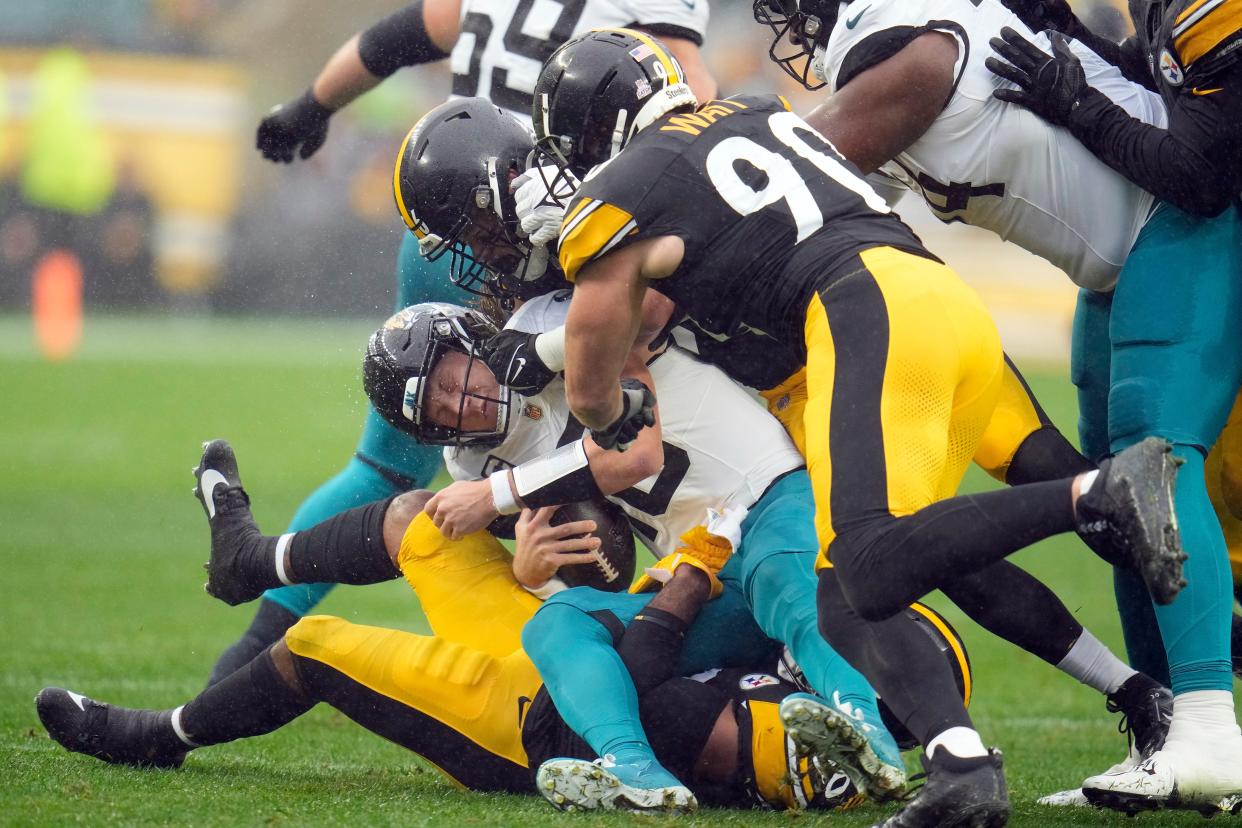 Jacksonville Jaguars quarterback Trevor Lawrence (16) is sacked by Pittsburgh Steelers linebacker Elandon Roberts (50), linebacker Alex Highsmith (56), and linebacker T.J. Watt (90) during the first half of an NFL football game Sunday, Oct. 29, 2023, in Pittsburgh. (AP Photo/Gene J. Puskar)