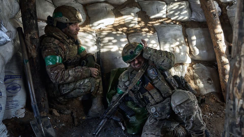 Ukrainian soldiers huddle under cover during artillery fire as the soldiers of Ukrainian National Guard hold their positions in the snow-covered Serebryan Forest on January 12, 2024 in Kreminna, Donetsk Oblast, Ukraine. - Kostiantyn Liberov/Libkos/Getty Images