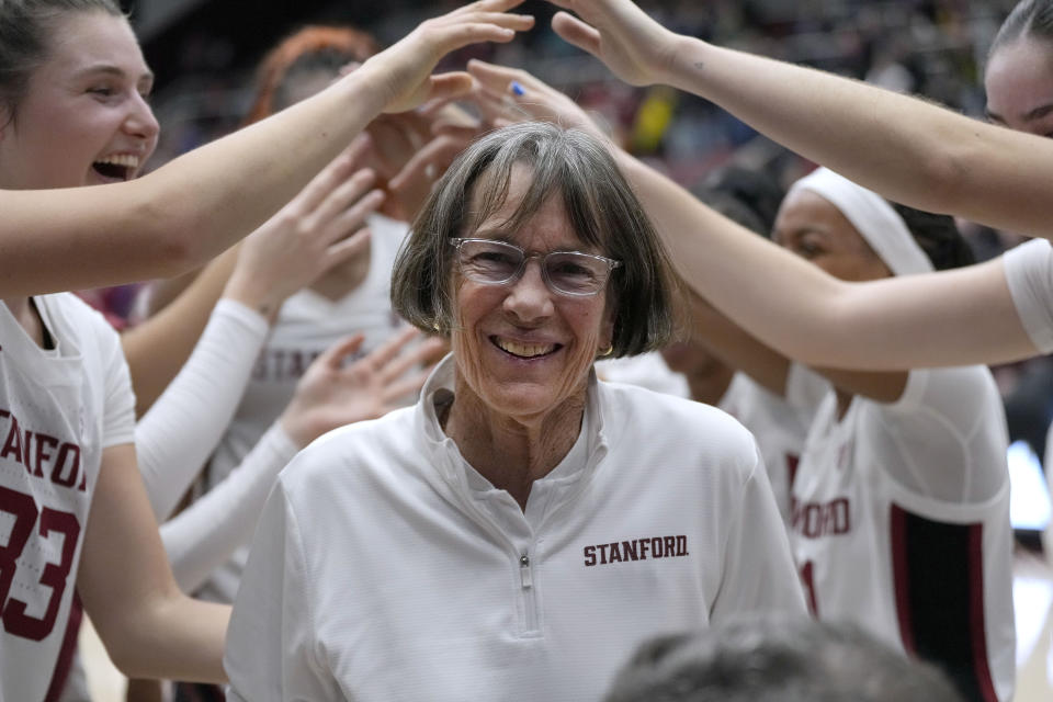 Stanford coach Tara VanDerveer smiles as players celebrate her 1,202nd victory as a college coach, against Oregon in an NCAA basketball game Friday, Jan. 19, 2024, in Stanford, Calif. VanDerveer tied former Duke men's basketball coach Mike Krzyzewski for the most wins. (AP Photo/Tony Avelar)