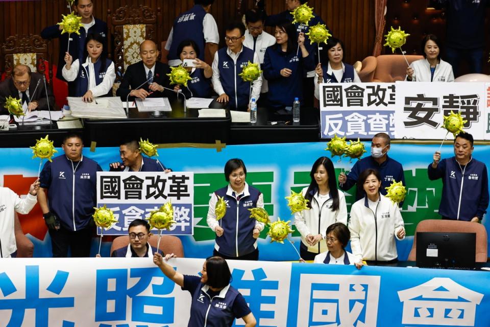 Taiwanese lawmakers of the Kuomintang (KMT) holding props stand near the Parliament President Han Kuo-yu to prevent the Democratic Progressive Party’s legislators from approaching, at the chamber inside the Legislative Yua (EPA)