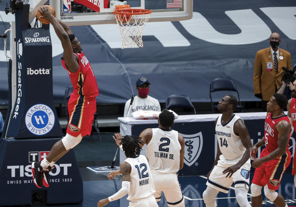 New Orleans Pelicans forward Zion Williamson (1) dunks over Memphis Grizzlies guard Ja Morant (12), forward Xavier Tillman (2) and center Gorgui Dieng (14) during the third quarter of an NBA basketball game in New Orleans, Saturday, Feb. 6, 2021. (AP Photo/Derick Hingle)