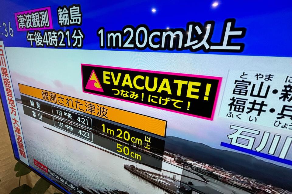 A tsunami warning is shown on TV in Yokohama, near Tokyo Monday, Jan. 1, 2024. Japan issued tsunami alerts Monday after a series of strong quakes in the Sea of Japan. (AP Photo/Eugene Hoshiko)