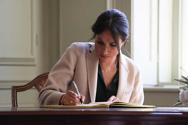 Meghan-signs-guestbook-sussex