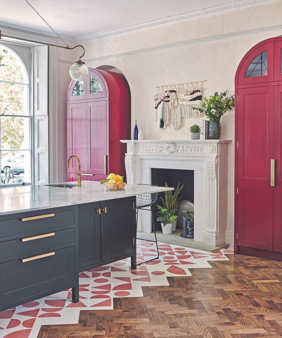 Red and white geometric tile floor with wooden floor, red door and matching cabinet