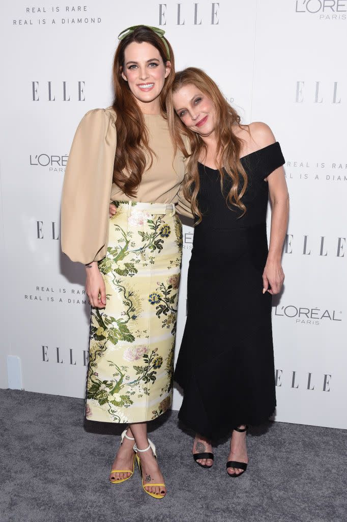 riley keough and lisa marie presely hugging and smiling on the elle carpet