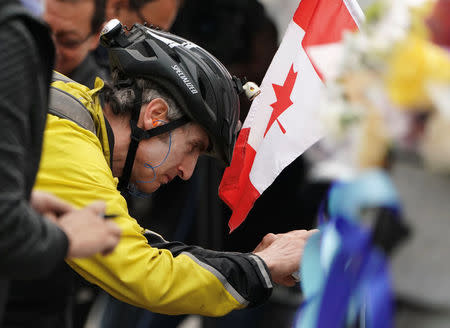 A mourner writes a message on a makeshift memorial a day after a van struck multiple people along a major intersection in north Toronto, Ontario, Canada, April 24, 2018. REUTERS/Carlo Allegri