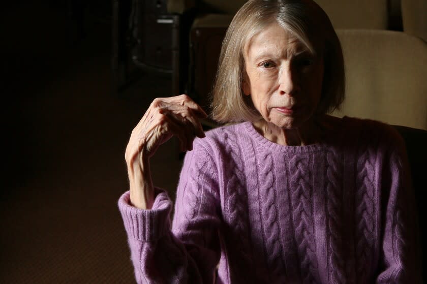 A woman posing in a cable-knit purple sweater