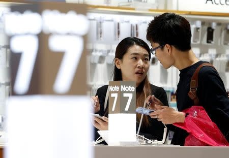 A couple tries out Samsung Electronics' Galaxy Note 7 at the company's headquarters in Seoul, South Korea, October 10, 2016. REUTERS/Kim Hong-Ji