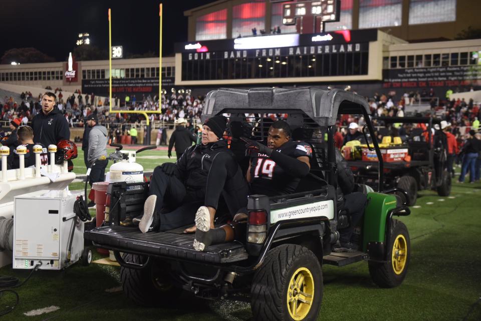 Texas Tech's linebacker Tyree Wilson (19) was examined on the sideline before a brace was placed on his right leg. He was carted to the football building.