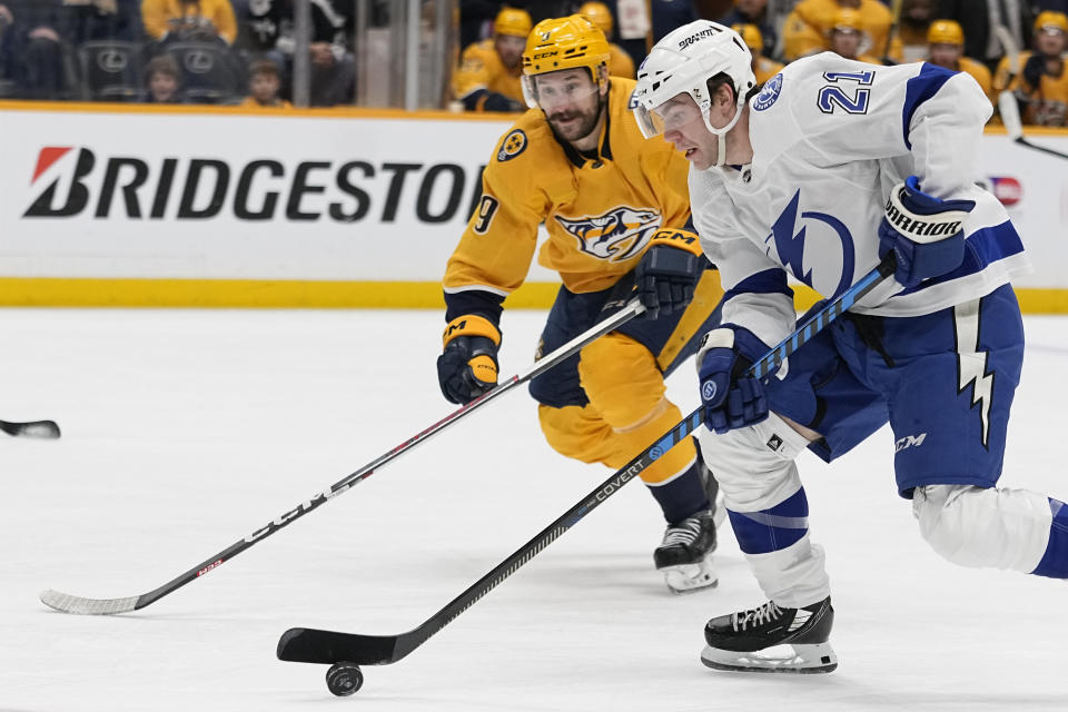 Tampa Bay Lightning center Brayden Point (21) skates the puck past Nashville Predators left wing Filip Forsberg (9) during the first period of an NHL hockey game Thursday, Dec. 7, 2023 in Nashville, Tenn. (AP Photo/George Walker IV)