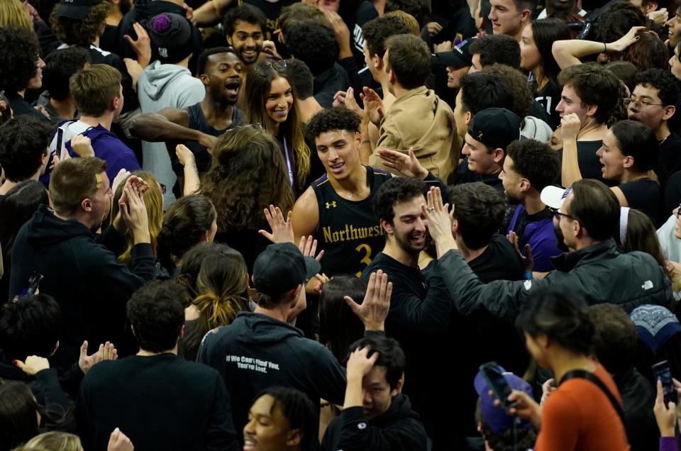 Northwestern guard Ty Berry, center, celebrates with students on court after defeating Purdue at Welsh-Ryan Arena.