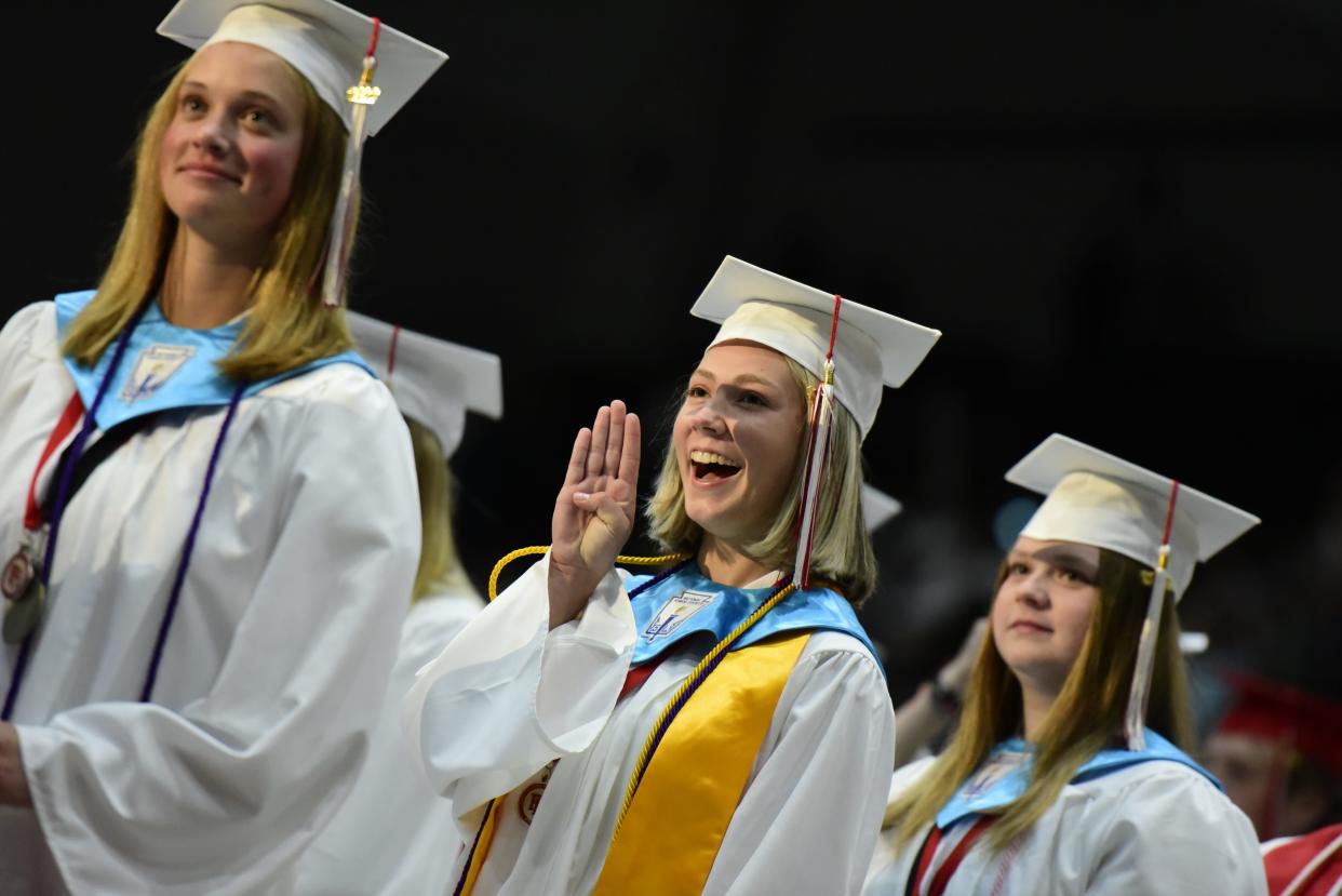 Graduating seniors smile while the band plays the school's fight song during the Port Huron High School commencement ceremony at McMorran Arena in Port Huron on Wednesday, June 8, 2022.