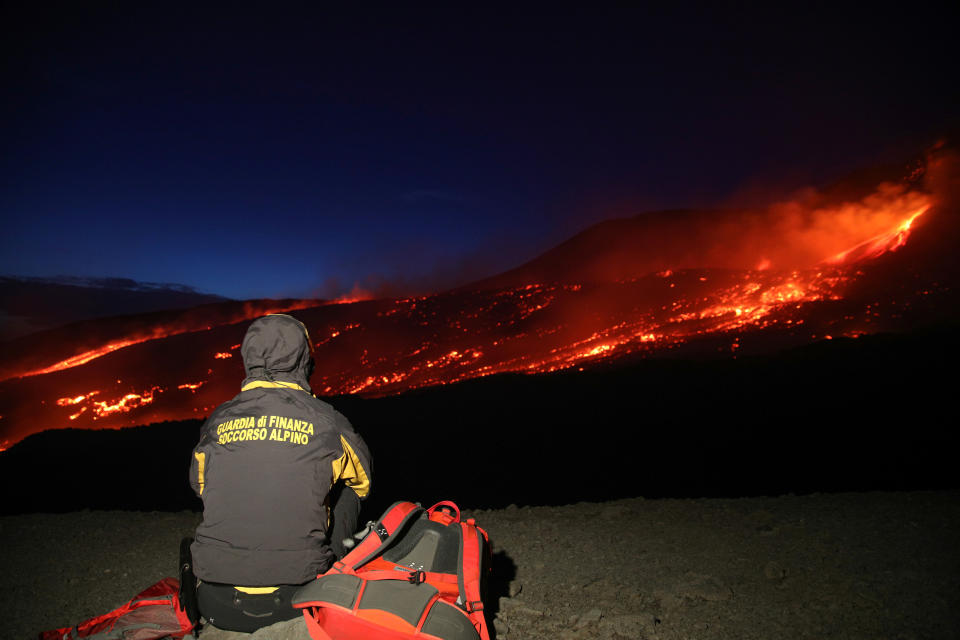 Member of the Guardia di Finanza alpine rescue looks on as Mount Etna, Europe's highest and most active volcano, erupts in Sicily, Italy, July 27, 2019. Picture taken July 27, 2019. REUTERS/Antonio Parrinello     TPX IMAGES OF THE DAY