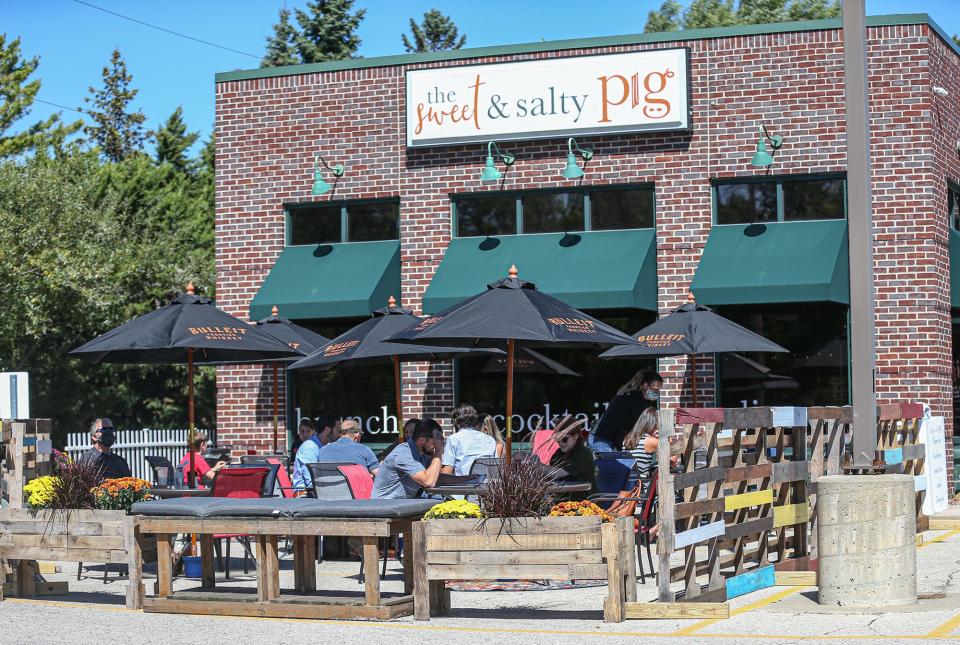 Diners sit in the new outdoor seating area at the Sweet & Salty Pig restaurant in Fond du Lac.