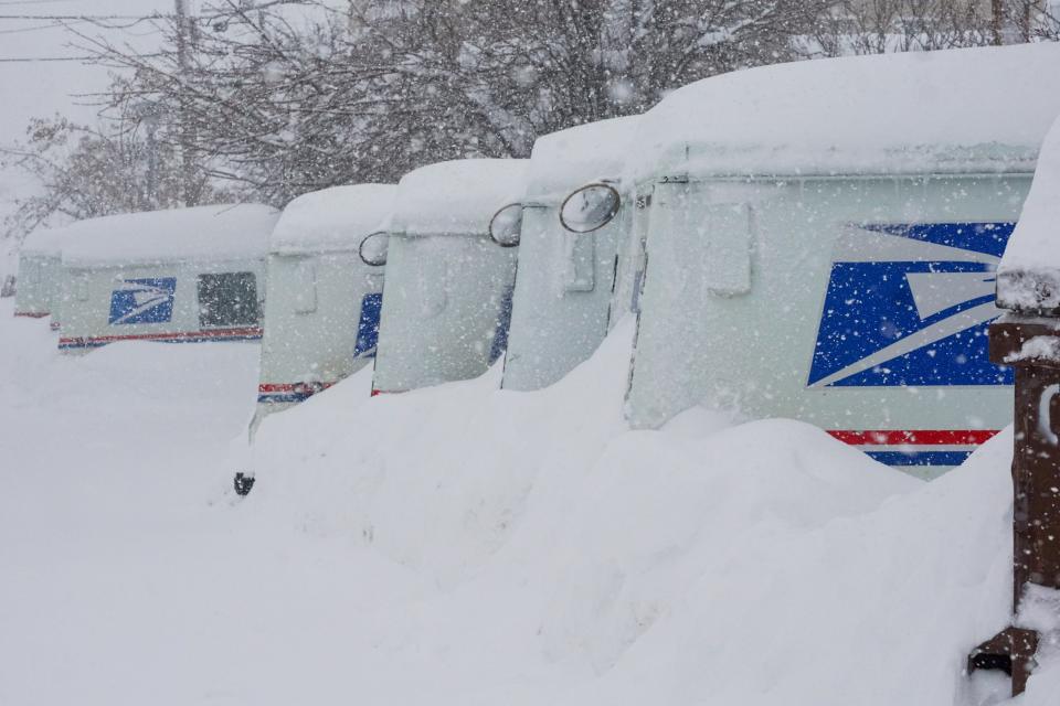 USPS trucks are covered in snow during a storm, Sunday, March 3, 2024, in Truckee, California.