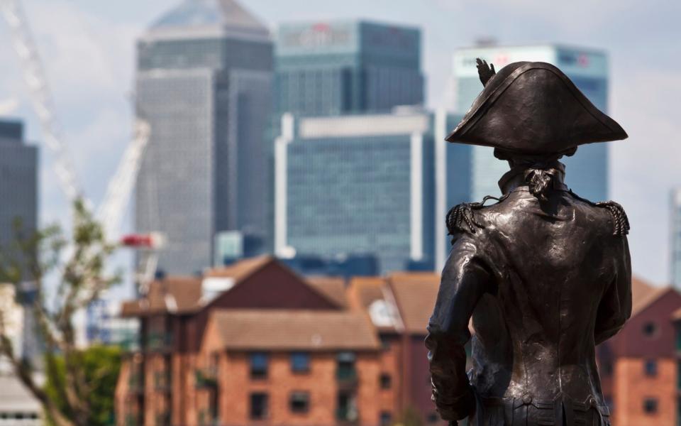 A statue of Lord Nelson in Greenwich, with Canary Wharf in the distance - bridgeman