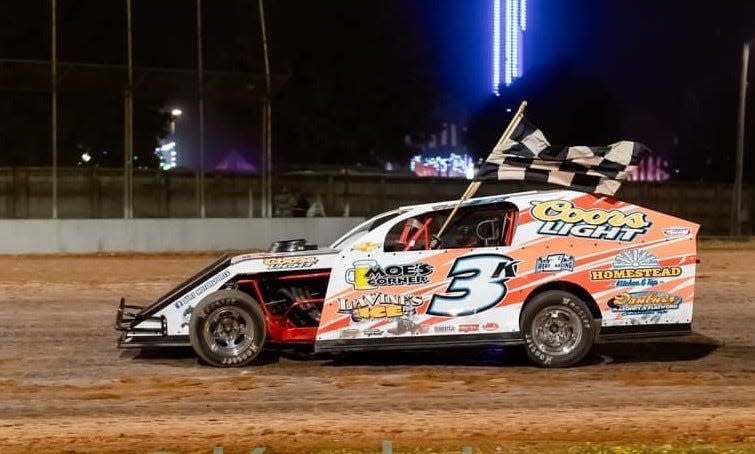 Todd Dart, the winningest race drivers in the history of The Hill Raceway in Sturgeon Bay, takes a victory lap after winning a Modified feature in 2023 at the track.