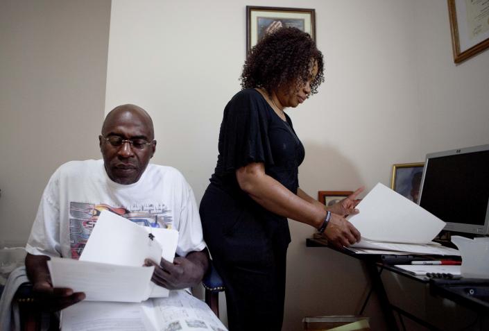 Michael, left, and Patricia Jackson sift through bank documents in their home Saturday, June 16, 2012, in Marietta, Ga. On a suburban cul-de-sac northwest of Atlanta, the Jacksons are struggling to keep a house worth $100,000 less than they owe. Their voices and those of many others tell the story of a country that, for all the economic turmoil of the past few years, continues to believe things will get better. But until it does, families are trying to hang on to what they've got left. The Great Recession claimed nearly 40 percent of Americans' wealth, the Federal Reserve reported last week. The new figures, showing Americans' net worth has plunged back to what it was in 1992, left economists shuddering. (AP Photo/David Goldman)