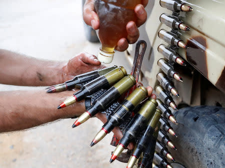 A fighter loyal to Libya's U.N.-backed government (GNA) oils bullets during clashes with forces loyal to Khalifa Haftar on the outskirts of Tripoli, Libya May 25, 2019. REUTERS/Goran Tomasevic