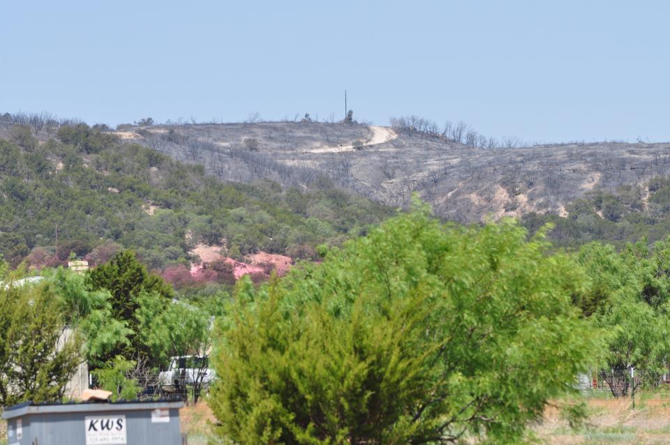 A charred hillside is visible near Braune Road and Hidden Valley Drive Wednesday. A wildfire that started Tuesday afternoon nearby on U.S. Highway 277 moved quickly through the area.