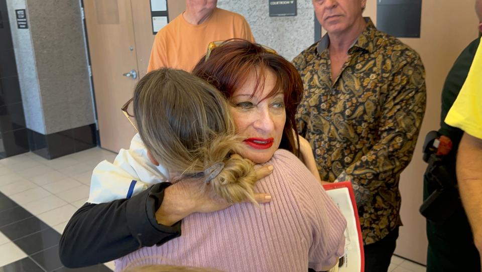 Cindy Falco DiCorrado, found guilty of refusing to wear a mask at a Boca Raton-area bagel shop and then resisting arrest for trespassing, is hugged by supporters after her sentencing hearing Monday, February 28, 2022.  