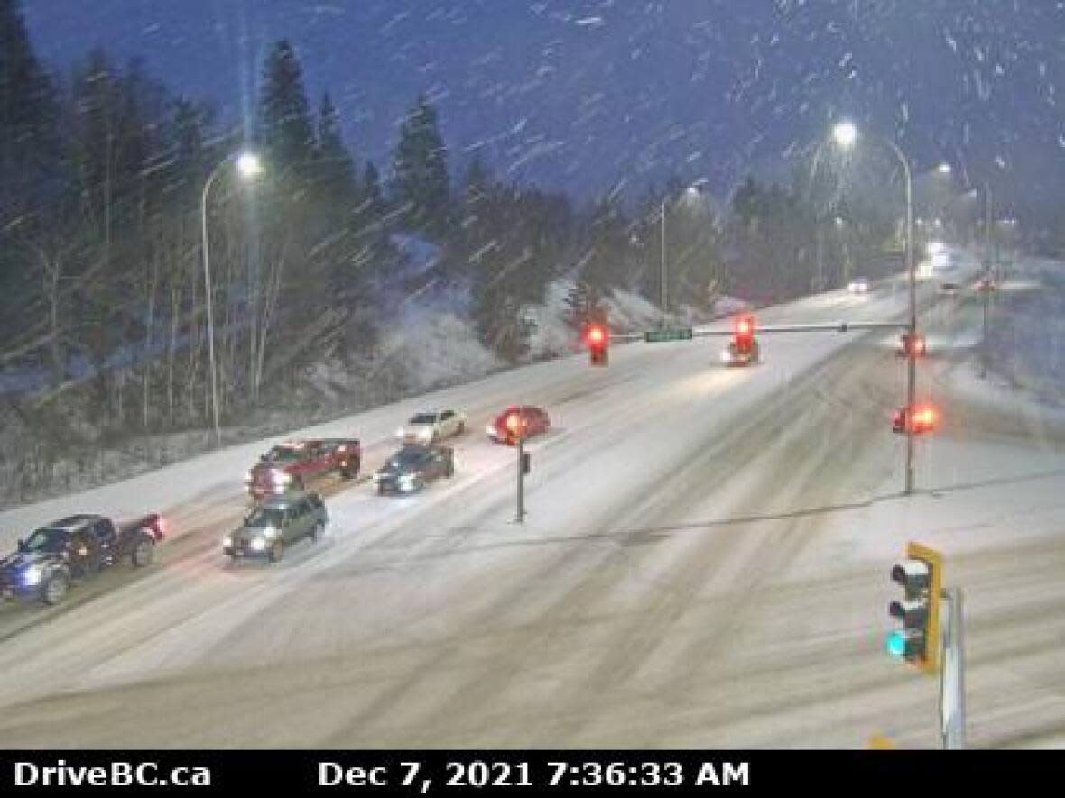 A DriveBC highway camera shot of the intersection at Highway 97 and Highway 16 in Prince George shortly after 7:30 a.m. PT Tuesday shows roads slick with snow. (DriveBC - image credit)