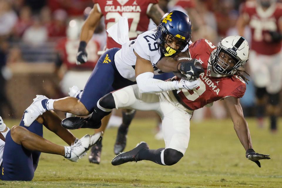 Oklahoma's Michael Woods II (8) is brought down by West Virginia's Sean Mahone (29) during a college football game between the University of Oklahoma Sooners (OU) and the West Virginia Mountaineers at Gaylord Family-Oklahoma Memorial Stadium in Norman, Okla., Saturday, Sept. 25, 2021. Oklahoma won 16-13. 