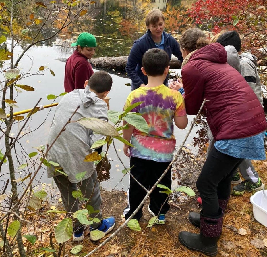 Students collect water samples from the Cocheco River as part of their yearlong project studying the life and health of the river.
