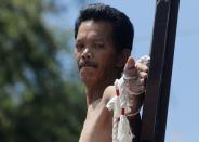 �Renato Cunanan, who portrays Jesus Christ, looks at the nail in his palm on a wooden cross during a Good Friday crucifixion re-enactment in San Juan village, Pampanga province, north of Manila.