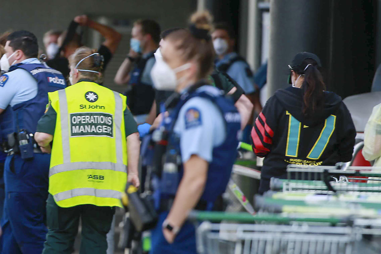 Police and ambulance staff attend a scene outside an Auckland supermarket, Friday, Sep. 3, 2021. New Zealand authorities say they shot and killed a violent extremist after he entered a supermarket and stabbed and injured six shoppers. Prime Minister Jacinda Ardern described Friday's incident as a terror attack. (Alex Burton/New Zealand Herald via AP)