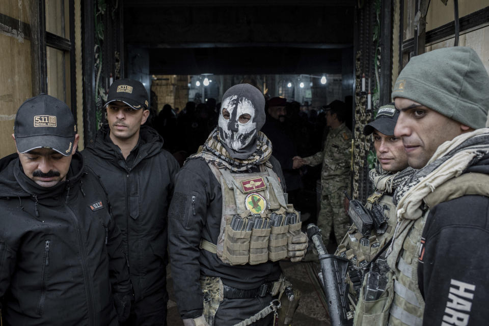 Iraqi forces guard the entrance to a Christmas Eve's Mass at the Assyrian Orthodox church of Mart Shmoni, in Bartella, Iraq, Saturday, December 24, 2016. For the 300 Christians who braved rain and wind to attend the mass in their hometown, the ceremony provided them with as much holiday cheer as grim reminders of the war still raging on around their northern Iraqi town and the distant prospect of moving back home. Displaced when the Islamic State seized their town in 2014, they were bused into the town from Irbil, capital of the self-ruled Kurdish region, where they have lived for more than two years. (AP Photo/Cengiz Yar)