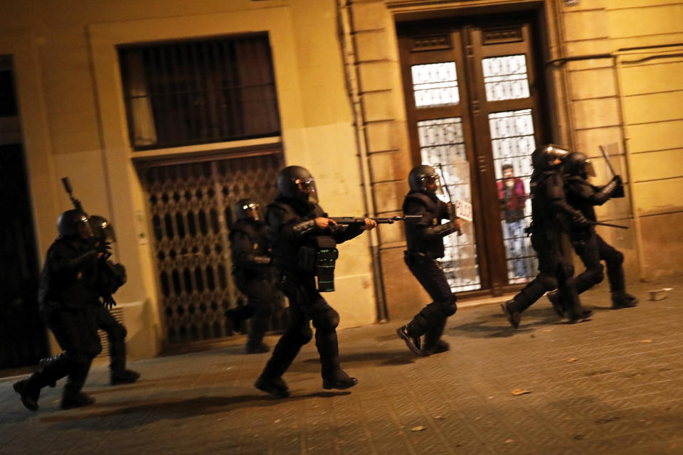 Police in riot gear moves after protestors during clashes in Barcelona, Spain, Wednesday, Oct. 16, 2019. Spain's government said Wednesday it would do whatever it takes to stamp out violence in Catalonia, where clashes between regional independence supporters and police have injured more than 200 people in two days. (AP Photo/Bernat Armangue)