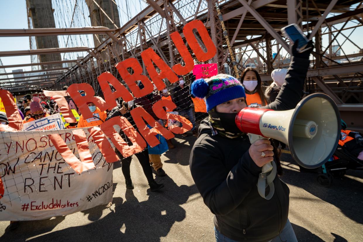 Protestors march across the Brooklyn Bridge to demand funding for excluded workers in the New York State budget on 5 March 2021 (Getty Images)