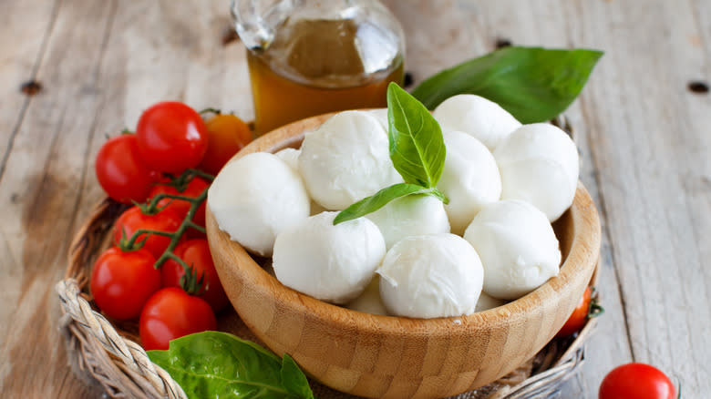 bowl of fresh mozzarella balls, tomato, oil, and basil