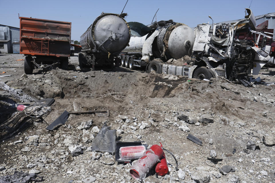 A crater is seen next to destroyed trucks after Russian shelling in Rozumivka, near Zaporizhzhia, Ukraine, Tuesday, June 20, 2023. (AP Photo/Andriy Andriyenko)