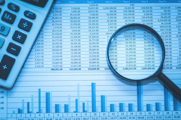 A spreadsheet with a magnifying glass laying on it.