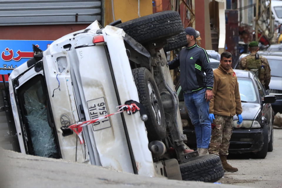 Lebanese soldiers stand next to a turned over UN peacekeeper vehicle at the scene where a UN peacekeeper convoy came under gunfire in the Al-Aqbiya village, south Lebanon, Thursday, Dec. 15, 2022. (AP Photo/Mohammed Zaatari)