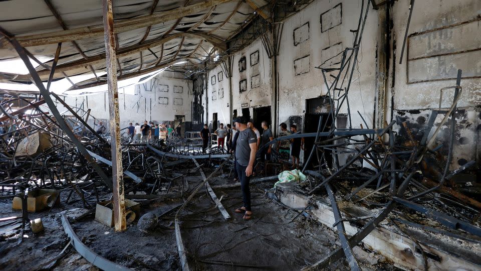 Locals can be seen walking through the debris of a wedding hall destroyed by a fire in Qaraqosh, in northern Iraq, on September 27. - Khalid Al-Mousily/Reuters