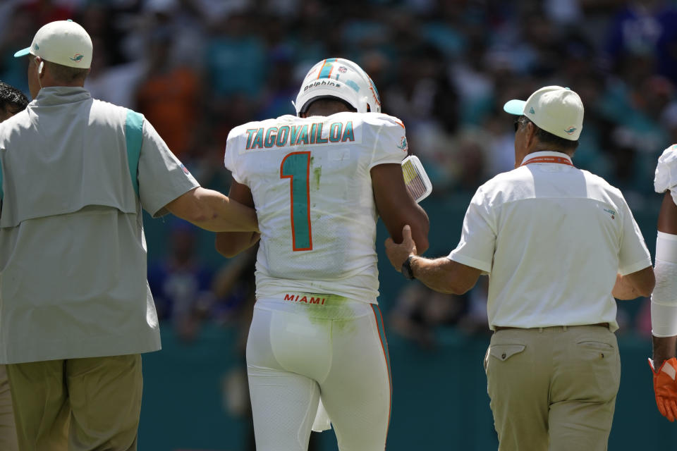 Miami Dolphins quarterback Tua Tagovailoa (1) is assisted off the field during the first half of an NFL football game against the Buffalo Bills, Sunday, Sept. 25, 2022, in Miami Gardens. (AP Photo/Rebecca Blackwell)