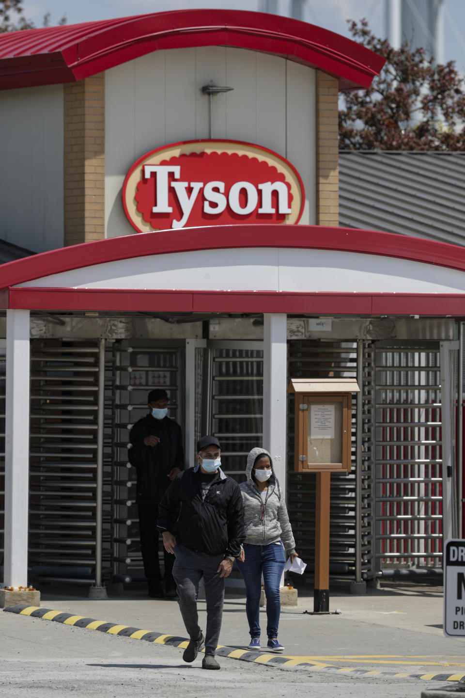 Workers leave the Tyson Foods pork processing plant in Logansport, Ind., Thursday, May 7, 2020. The plant was expected to reopen Thursday after closing on April 25 after nearly 900 employees tested positive for the coronavirus. Workers won't be able to return to work until they get tested. (AP Photo/Michael Conroy)