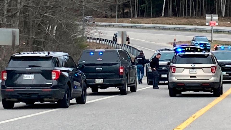Members of law enforcement approach vehicles at a scene where people were injured in a shooting on Interstate 295 in Yarmouth, Maine, Tuesday, April 18, 2023 (AP)