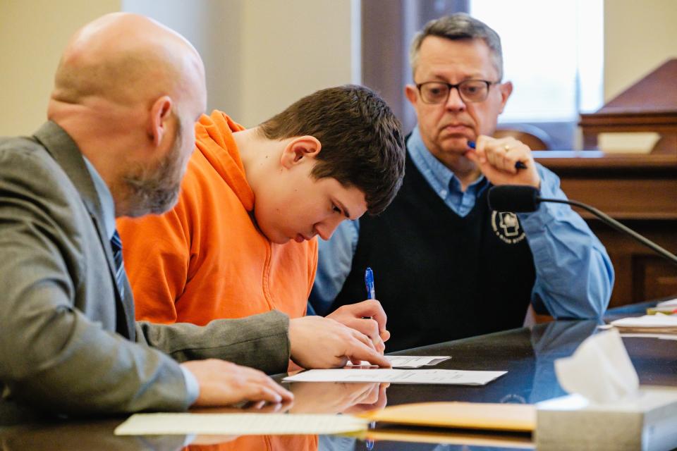 Gavin T. Kurtz signs a form waiving his right to a speedy trial during his arraignment hearing on charges of attempted murder, felonious assault, and improperly handling firearms in a motor vehicle in the Tuscarawas County Common Pleas Court. His attorney Dan Guinn, left, and Tuscarawas County Prosecutor Ryan Styer are shown with him.