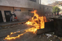 A roadblock set up by anti-government protesters burns during clashes with security forces after an apparent mutiny by a national guard unit in the Cotiza neighborhood of Caracas, Venezuela, Monday, Jan. 21, 2019. (AP Photo/Fernando Llano)