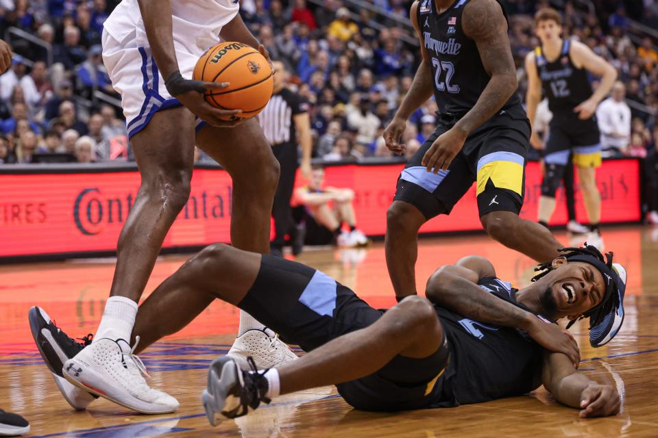 Marquette guard Chase Ross goes down with a shoulder injury during the first half Saturday.